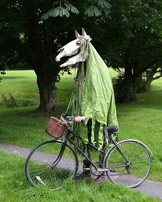 a horse head is attached to the back of a bicycle with a cloth draped over it