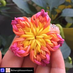 someone is holding a ring made out of colorful yarns and plastic beads in their hand