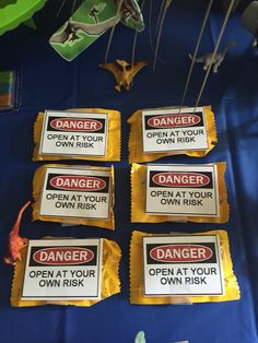 some kind of warning signs that are on top of a blue table cloth with other items in the background