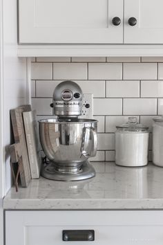 a silver mixer sitting on top of a kitchen counter