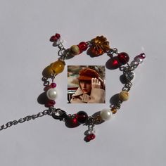 a bracelet with a photo of a woman wearing a red hat and pearls on it