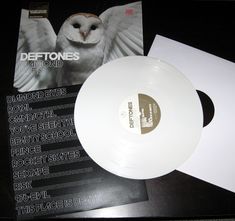 a white vinyl record sitting on top of a table next to an envelope with the words dettones in it