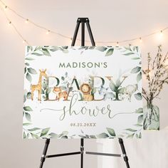 a baby shower sign on a easel with lights in the background