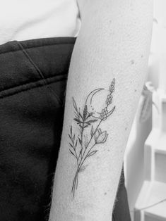 a black and white photo of a person with a flower tattoo on their arm,