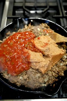 a pan filled with meat and sauce on top of a stove