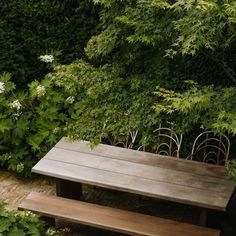 a wooden bench sitting in the middle of a garden