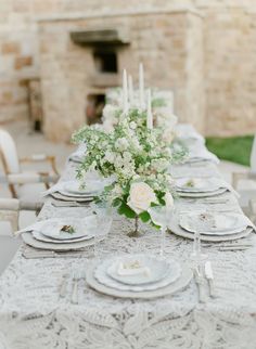 the table is set with white plates and silverware