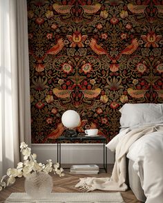 a room with a bed, table and wall paper on the walls that has an intricate design