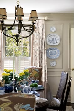 the dining room table is set with blue and white china