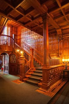 a large wooden staircase in an old style house with wood paneling and columns on the walls