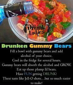 a bowl filled with gummy bears next to a bottle