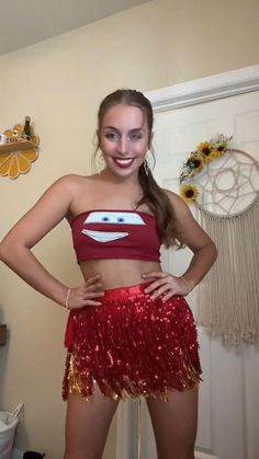 a girl in a red and gold costume posing for the camera with her hands on her hips