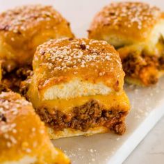 cheeseburger sliders on a white plate with powdered sugar sprinkled on top