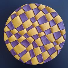 a purple and yellow plate with squares on it's surface, in the shape of a circle