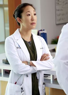 a woman in a white lab coat standing with her arms crossed