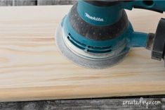 a sanding machine on top of a wooden board