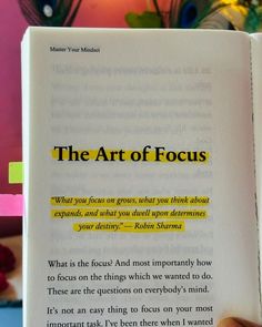 a person holding an open book with the title'the art of focus'written on it