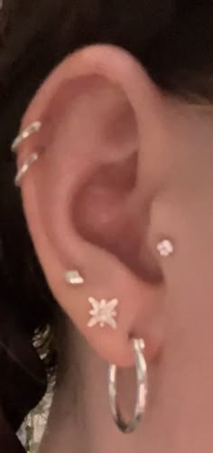 a close up of a person's ear with small white flowers on the side