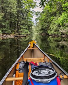 there is a boat that is going down the river with trees in the back ground