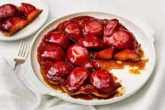 two white plates topped with desserts covered in syrup next to forks and napkins