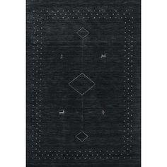 a black area rug with white dots and diamonds on the bottom, in front of a gray background