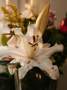 there is a vase with flowers in it and one has white lilies on the inside