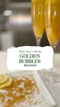 two glasses of champagne are sitting on a white plate with gold bubbles and lemon slices