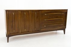 a wooden sideboard with brass handles and drawers