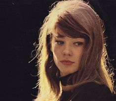 a close up of a person wearing a black shirt and long hair with bangs on her head