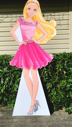 a cardboard cutout of a barbie doll standing on top of a white pedestal with pink dress and high heels