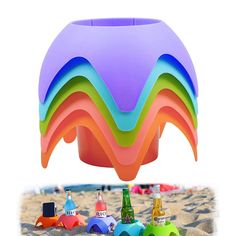 there are many different colored objects in the sand and one has a plastic umbrella over it