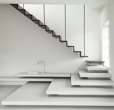 an empty room with white walls and stairs