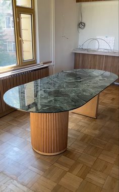 a large marble table sitting in the middle of a room with wooden floors and walls