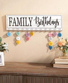 a family birthday sign hanging on the wall next to a vase with flowers in it