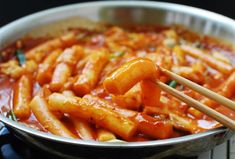 some food is being cooked in a pan with chopsticks sticking out of it