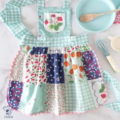 a child's apron, bowl and utensils laid out on a table