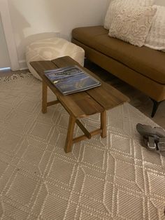 a living room with a couch, coffee table and two shoes on the floor in front of it