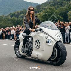 a woman riding on the back of a white motorcycle down a street next to a crowd