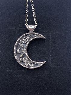 "A crescent shaped moon with a solid bail. Inside the moon is a floral scrollwork pattern. We cast this is solid sterling silver, with a dark patina to really make it pop! Pendant including bail is 26mm high and 20mm wide. This item is custom made to order. That means it may take an extra second or two to make your entire piece by hand. We try to beat shipping estimates, but its just a one woman team in this shop! Our supplier of casting grain uses SCS-certified 100% recycled metal. We make ever Moon Pendant Necklace Silver, Spiritual Crescent Engraved Jewelry, Elegant Crescent Jewelry With Oxidized Finish, Elegant Crescent Oxidized Jewelry, Engraved Sterling Silver Crescent Jewelry, Vintage Moon Shaped Sterling Silver Jewelry, Silver Half Moon Jewelry Engraved, Vintage Sterling Silver Moon Jewelry, Silver Half Moon Engraved Jewelry