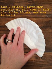 a person's hand on top of a piece of paper with the words take 3 filters, layer them together and fold them in half for filter blooms, use more filters