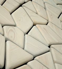 many wooden pieces are arranged together in the shape of an abstract pattern, including triangles