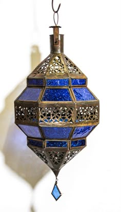 a blue and gold hanging light fixture against a white wall