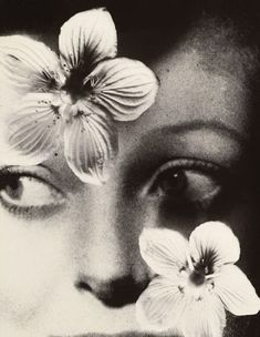 a woman's face with two flowers on her forehead and one flower in front of her eye