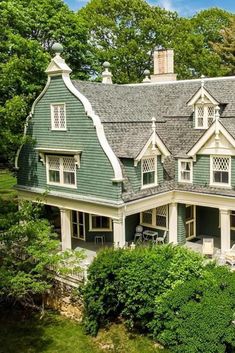 an aerial view of a large green house with white trim and two storyed windows