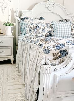 a white bed sitting next to a dresser with drawers