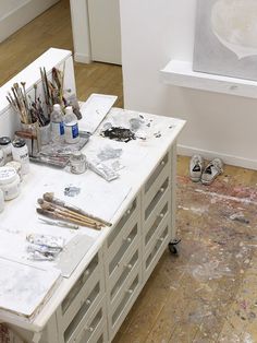 three different views of an artist's studio with various paints and brushes on the table