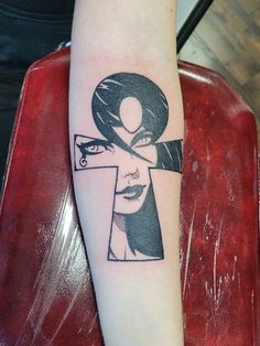 a woman's arm with a black and white tattoo design on the left forearm