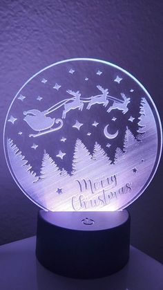 an illuminated christmas ornament is shown on a stand with the words merry christmas