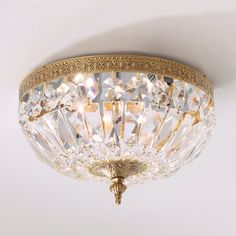 a close up of a light fixture on a white ceiling with gold trimmings