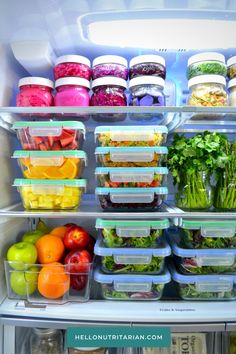 an open refrigerator filled with lots of different types of vegetables and fruit in plastic containers